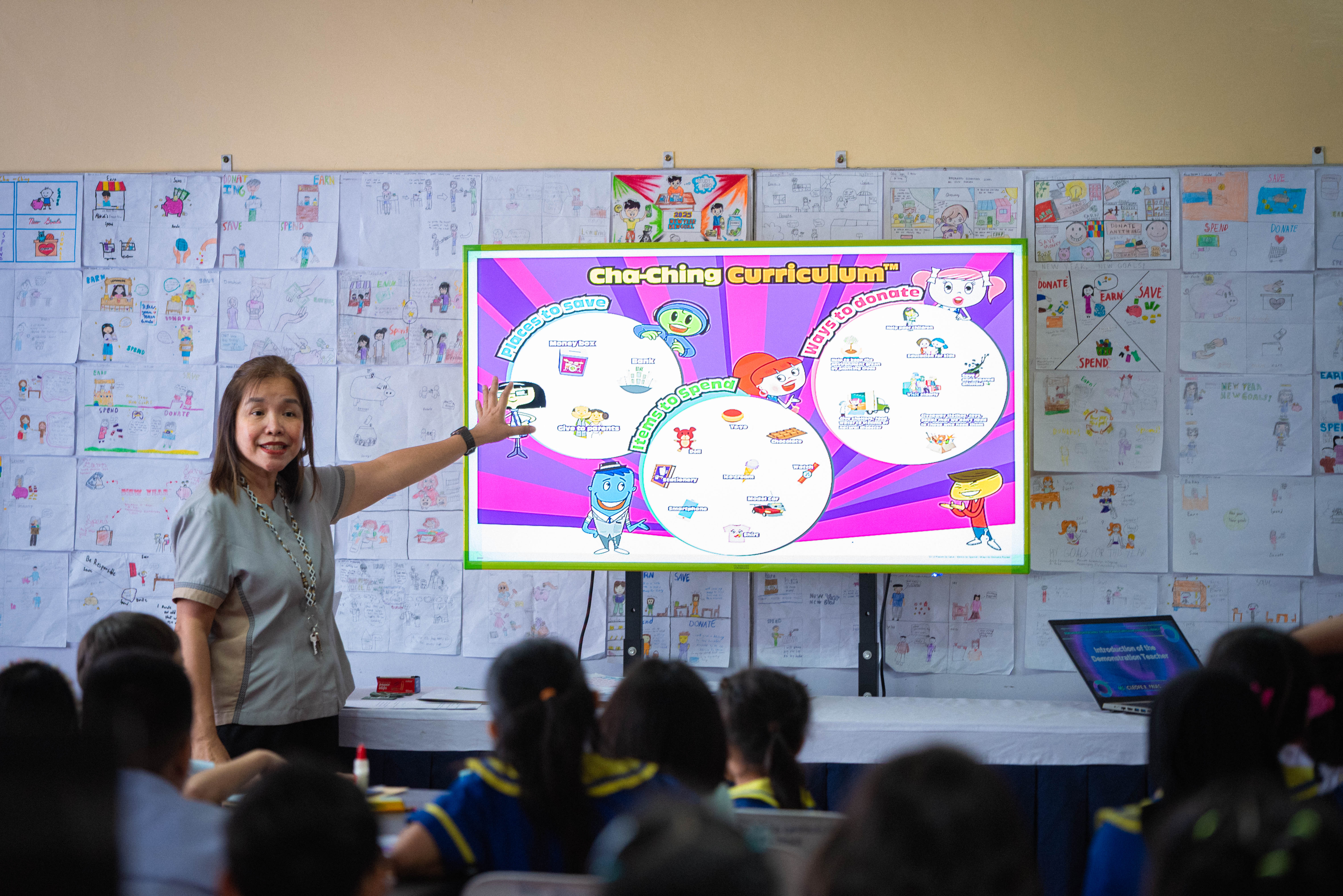 A teacher introduces the key Cha-Ching money-smart concepts to Grade 4 students.