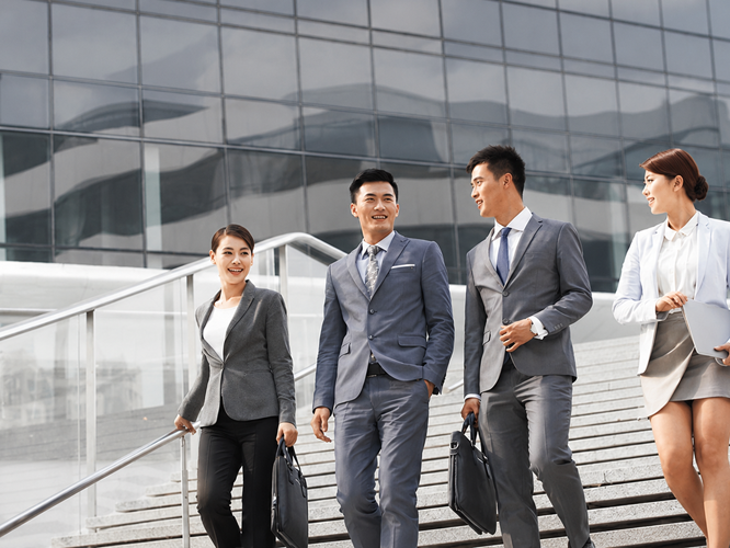 Three business profesionals walking down the stairs