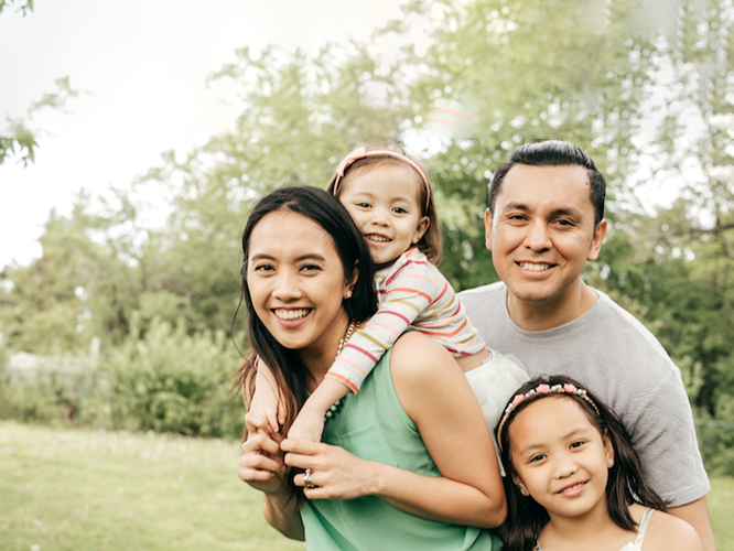 A family of four smiling together