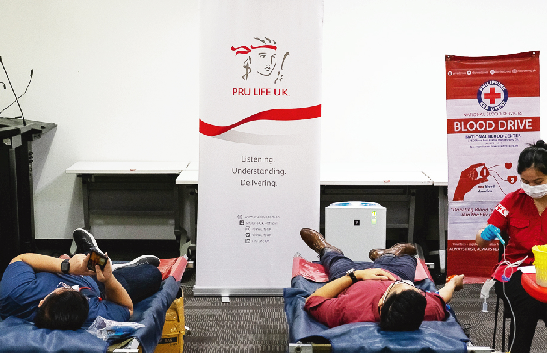 Two people getting their blood taken by a nurse