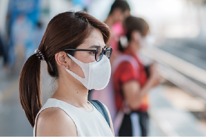 Girl with glasses and mask waiting outside