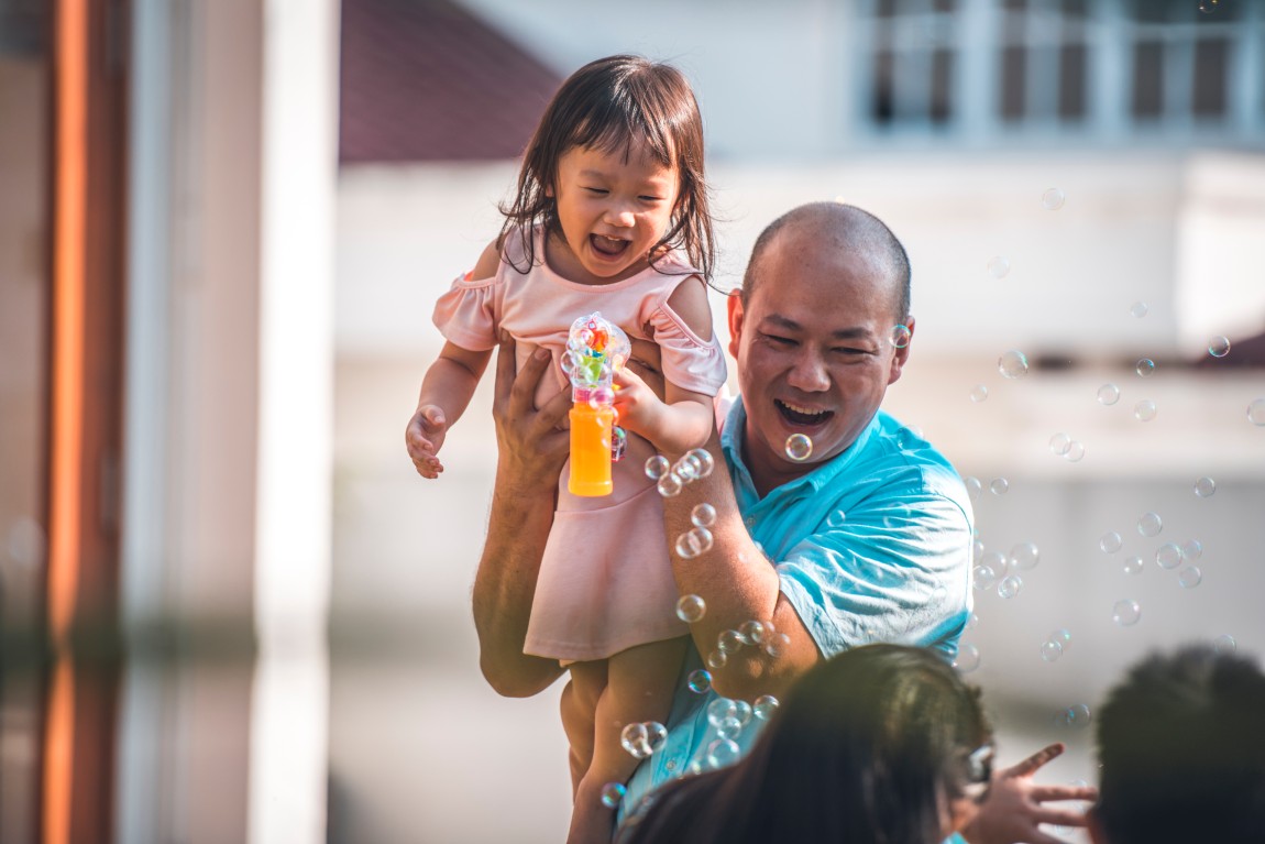 Father carrying his daughter while playing with