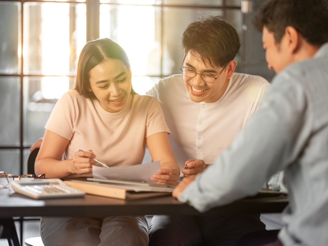 Three people happily discussing in the office.