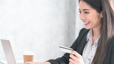 Smiling woman paying online using card