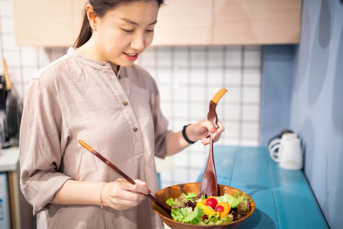 A woman making a bowl of salad