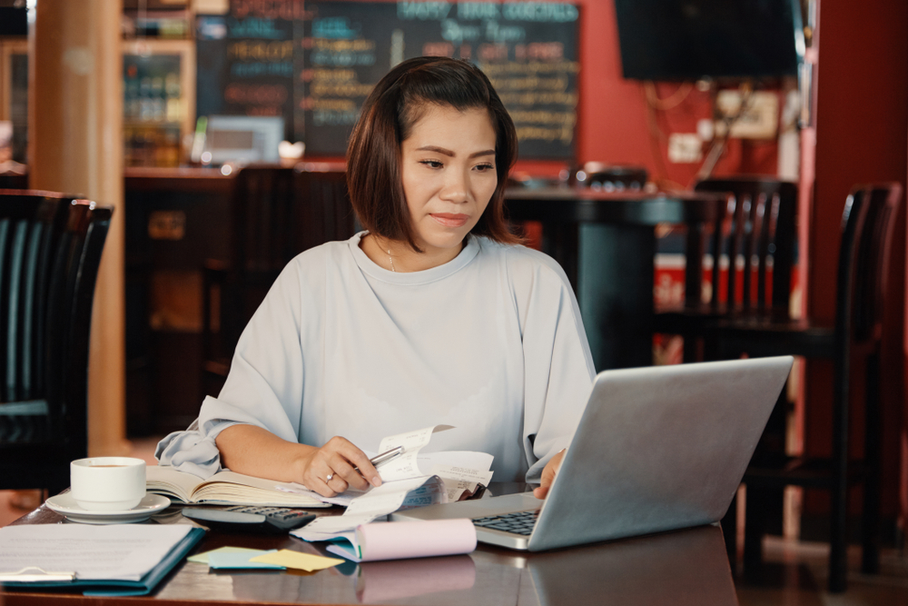 A woman working with receipts and journal